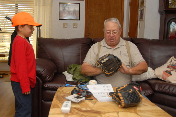 Grandpa inspects the baseball gloves
