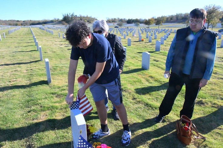 placing a flag at Grandpa Bill's gravesite